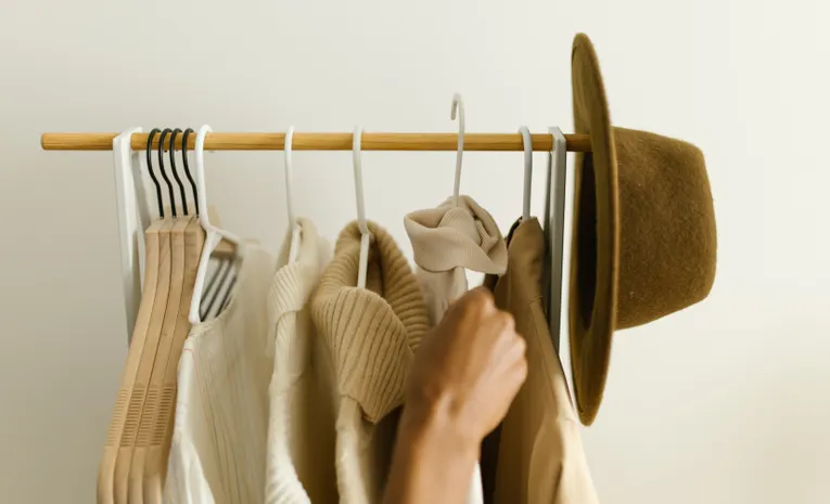 Neutral toned capsule wardrobe hanging on a rack