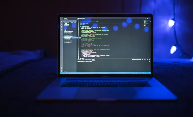Programming code on a computer screen in a dark room