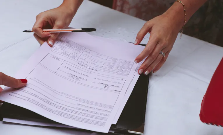 Person reviewing documents and paperwork at a desk
