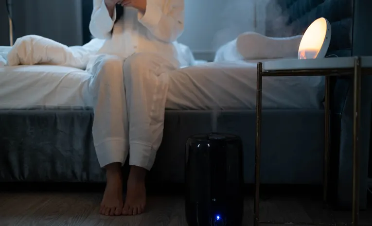 Air humidifier releasing steam in a bedroom