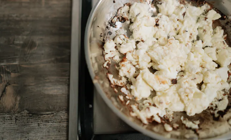 Overcooked food in a stainless steel pan on the stove